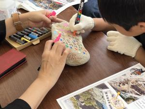 栗石に絵を書いている写真