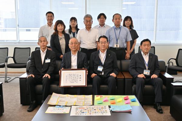 感謝状贈呈式に出席した秋山社長、市長、教育長、中央図書館長、寄贈先小学校長らの写真