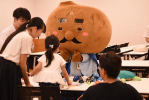 うちわと廃材を使ってじゅうじゅうと子どもが遊ぶ様子