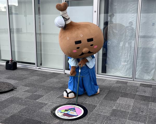 「とり奉行　骨付きじゅうじゅう」がマンホールの調整をしている様子